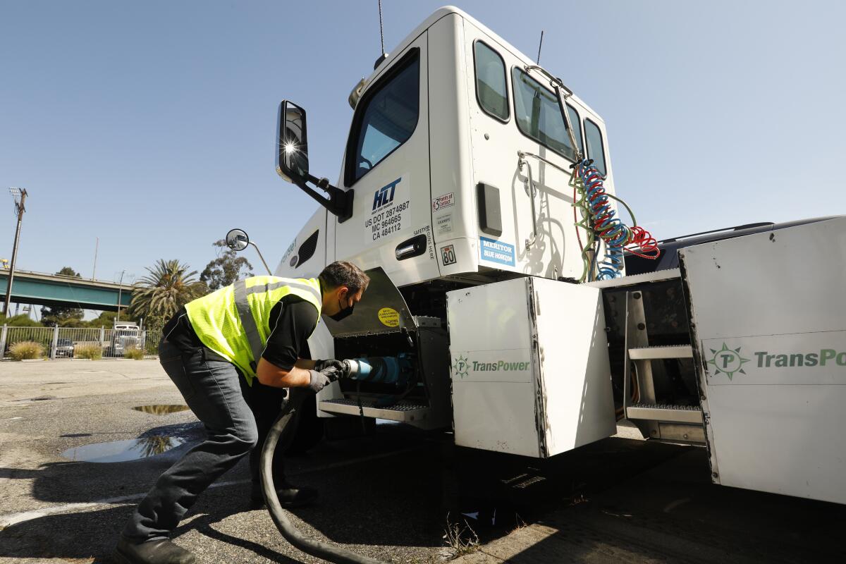Ryan Sickles of Total Transportation Services Inc. hooks up an electric truck to charge at the Port of Los Angeles.