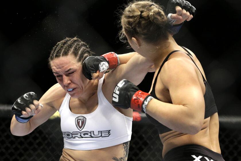 Ronda Rousey lands a punch against Alexis Davis during her UFC 175 victory.