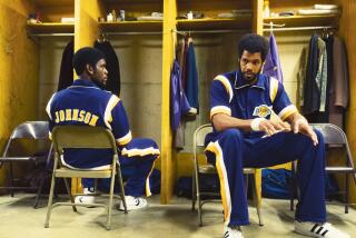 Quincy Isaiah as Magic Johnson seated in locker room next to Solomon Hughes as Kareem Abdul-Jabbar.