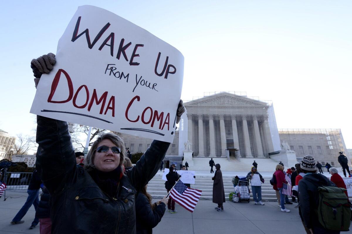 Carolyn Marosy, a supporter of same-sex marriage rights, holds a sign that reads "Wake Up From Your DOMA Coma" outside the U.S. Supreme Court on the day the high court hears the case challenging the Defense of Marriage Act (DOMA) in Washington, D.C.