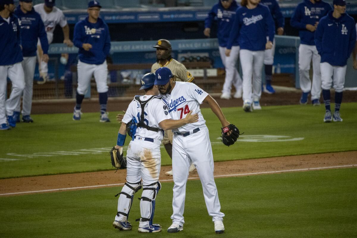 Dodgers reliever Kenley Jansen hugs catcher Will Smith after getting the save in the Dodgers' 5-4 win April 24, 2021.