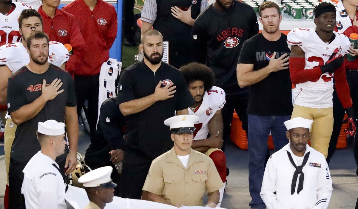 Former Green Beret Nate Boyer, second from right, stands next to a kneeling Colin Kaepernick during the national anthem on Thursday.