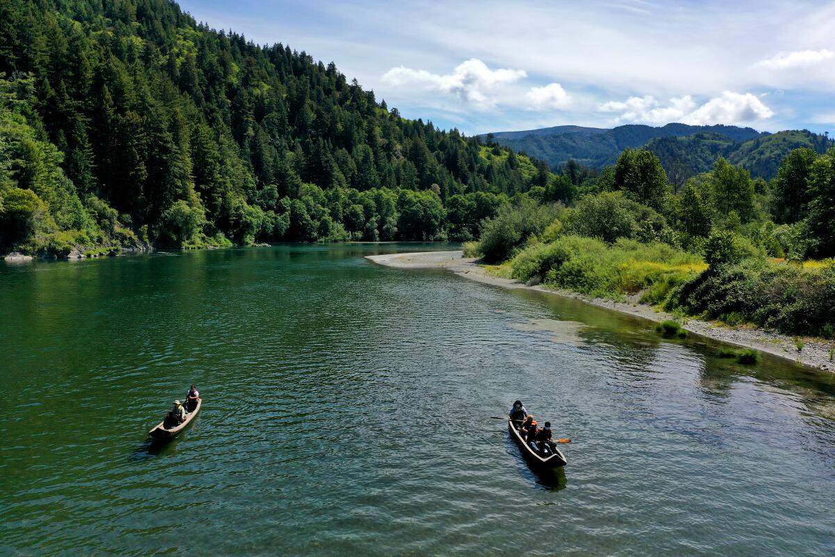 Yurok memandu pengunjung berkano di sepanjang Sungai Klamath dengan kano tradisional.