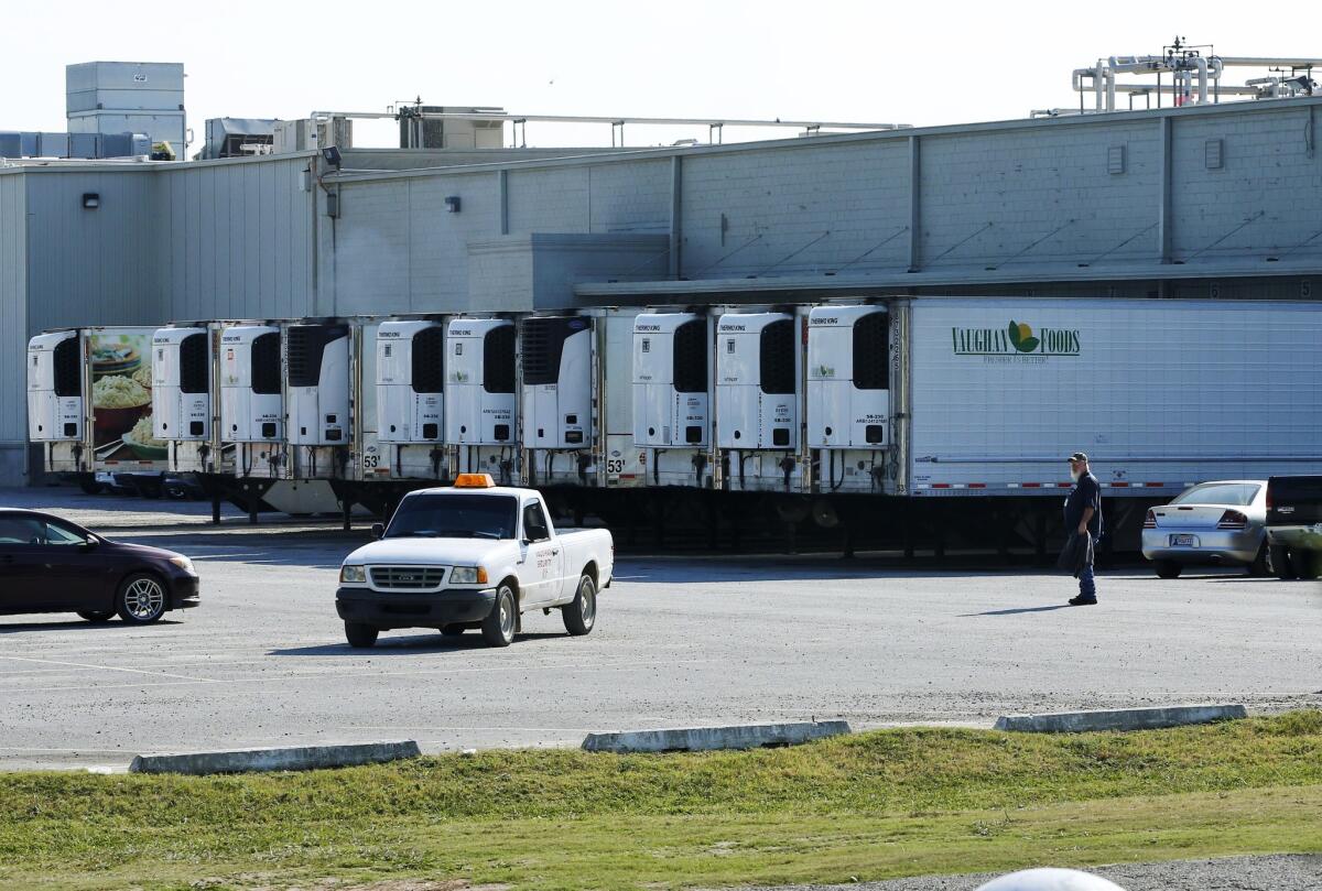 Trucks are parked Friday in a lot at Vaughan Foods in Moore, Okla., where a man beheaded a woman with a knife and attacked another.