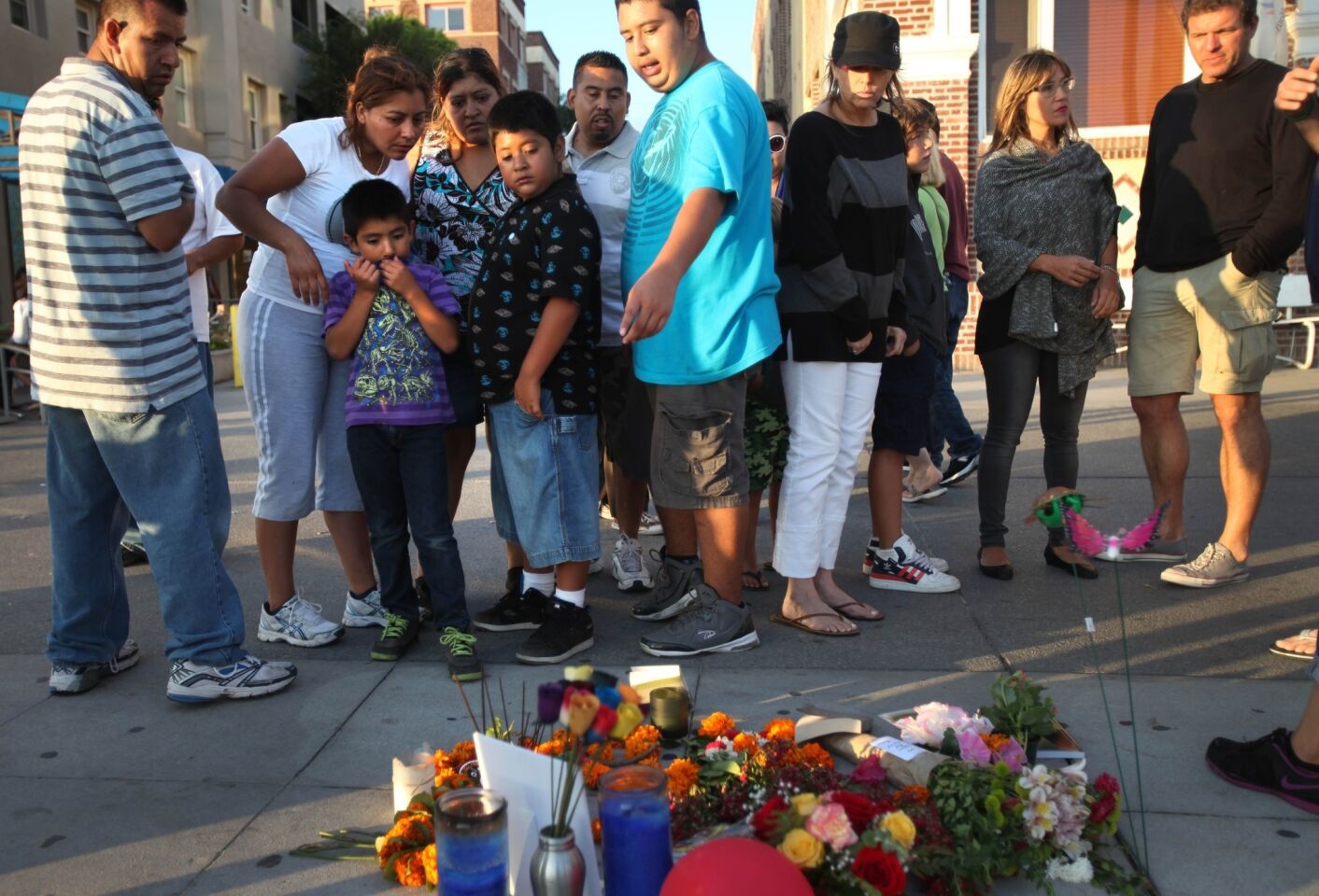 Visitors leave flowers and pay their respects at a memorial on the Venice boardwalk.