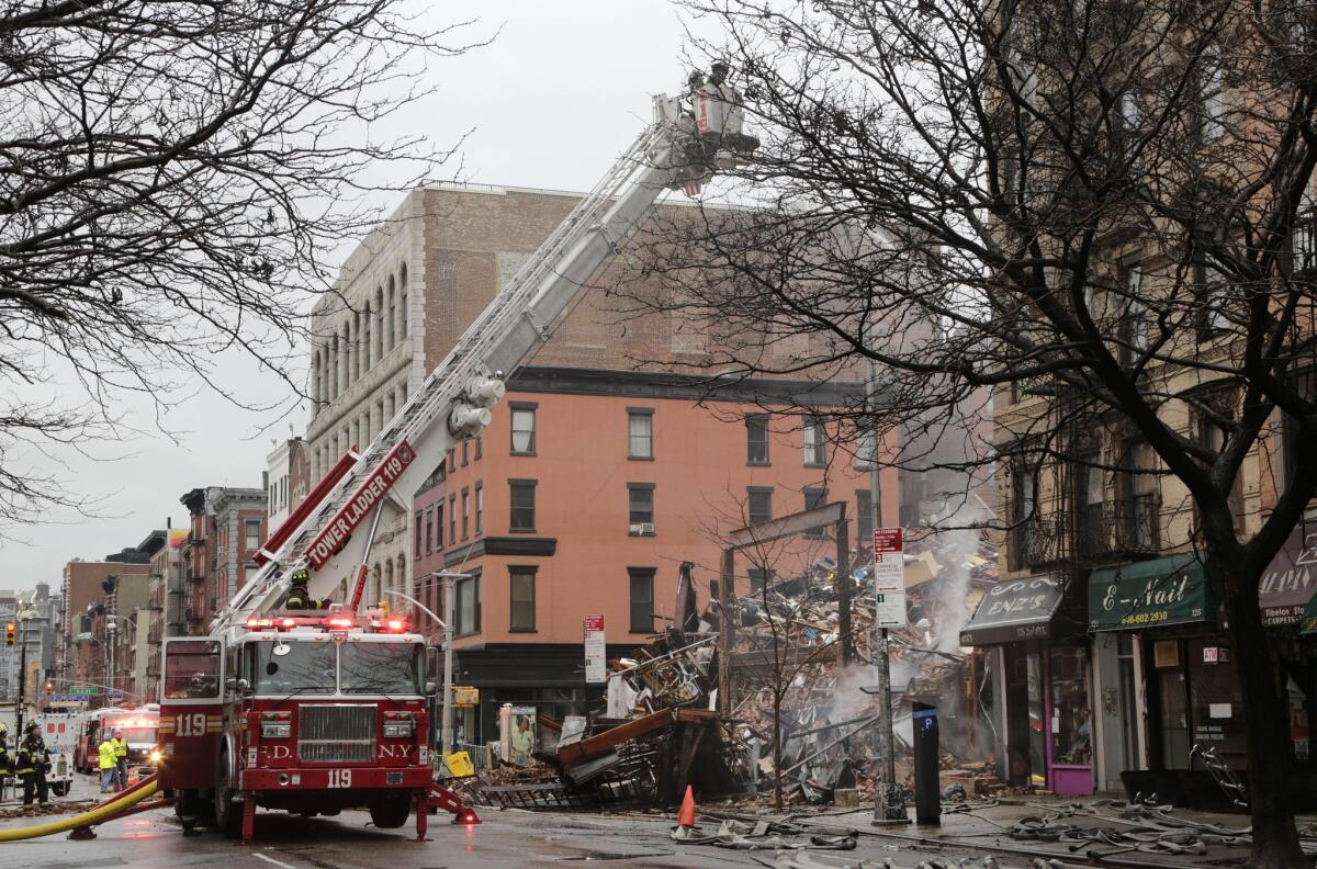 A firefighter on a ladder truck directs water onto the site of an explosion and fire in New York's East Village on March 27.