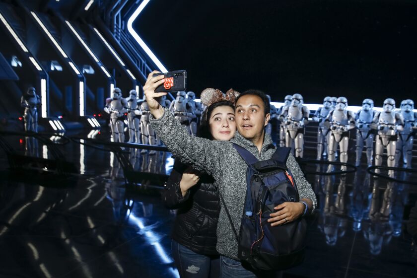 ORLANDO, FL --DECEMBER 05, 2019—Two people stop for a selfie with 50 Stormtroopers on opening day to the public, of Star Wars: Rise of the Resistance, inside Star Wars: Galaxy’s Edge at Disney’s Hollywood Studios, in Orlando, FL, Dec 05, 2019. A virtual ride queue was utilized, which allowed riders using the Walt Disney World app to register for a time to return to the line queue, but by 8:30 a.m., all reservations were taken. (Jay L. Clendenin / Los Angeles Times)