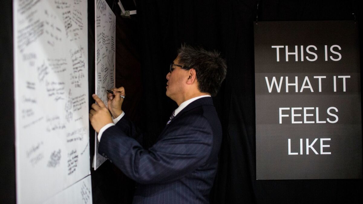 Democratic gubernatorial candidate John Chiang writes on a board as part of an interactive art installation during the California Democratic Convention.