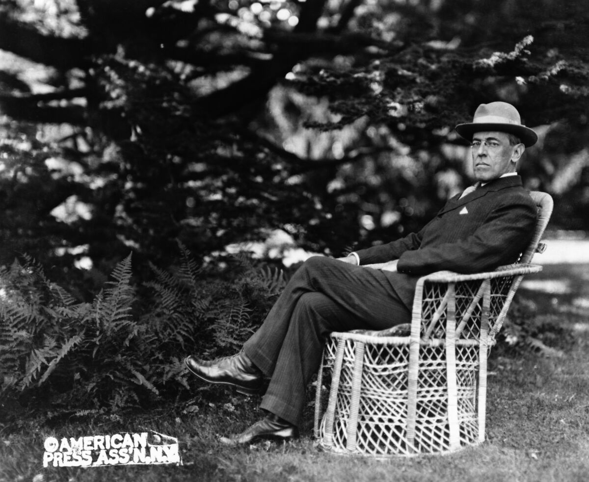 A portrait of President Woodrow Wilson seated outdoors, circa 1920.