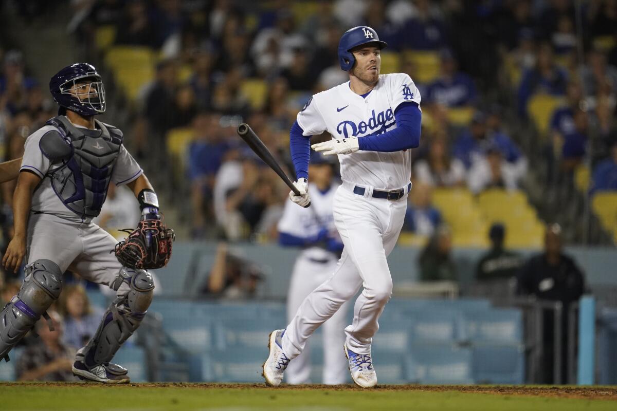 Freddie Freeman hits a single during the eighth inning of the Dodgers' 6-4 comeback win over the Rockies on Saturday.