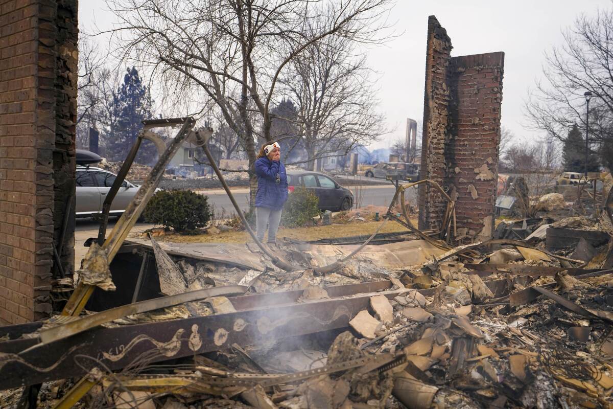 A woman reacts to seeing the remains of her mother's house.