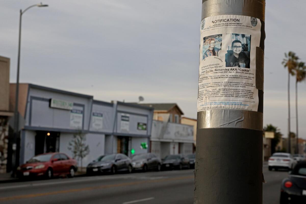 A Los Angeles Police Department missing person flyer hangs is taped to a post. 