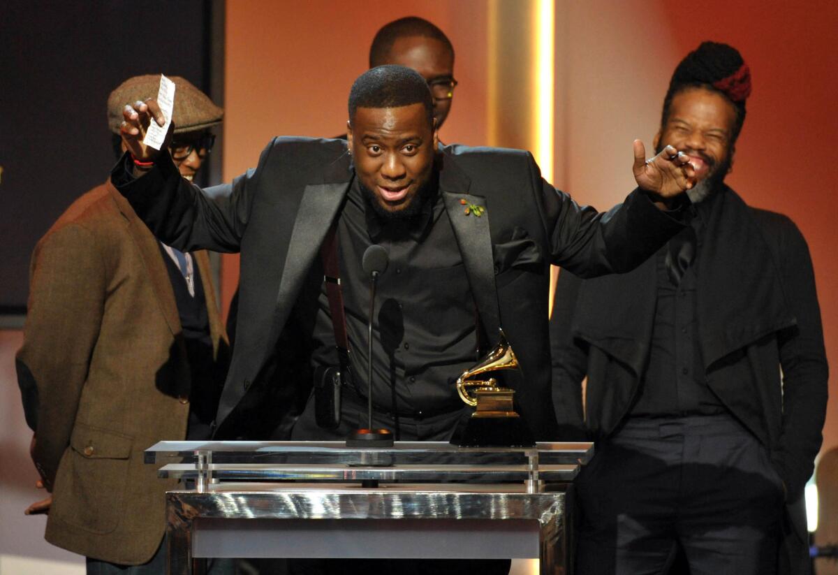 Robert Glasper, center, accepts the award for R&B; album for "Black Radio" during the Grammy Awards' pre-telecast Sunday in Los Angeles.