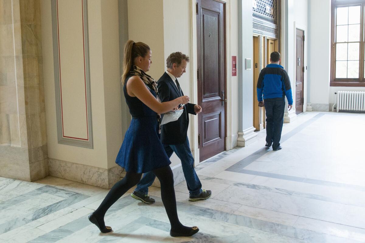 Republican presidential candidate Sen. Rand Paul of Kentucky walks around Capitol Hill in Washington. He led a mini-filibuster to delay passage of a federal budget deal.