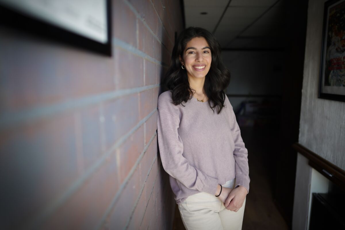 Ramah Awad, program director of the Majdal Center, leaning against a wall, smiling at the camera