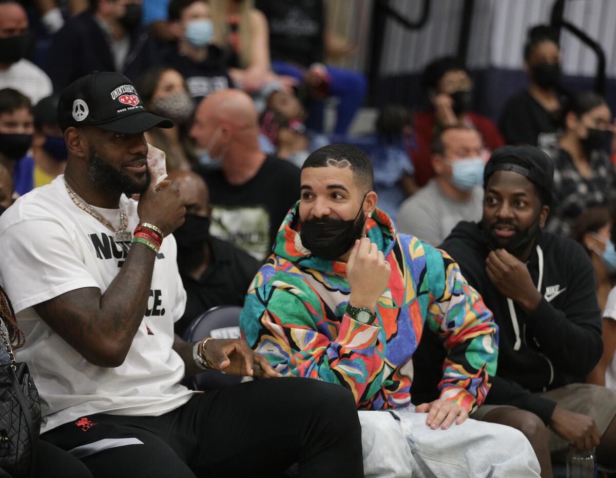 Lebron James, left, and Drake watch the Sierra Canyon-Corona Centennial Southern Section Open Division final.