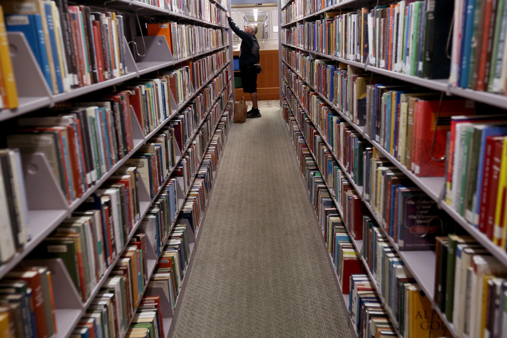 Richard DePriest looks for a book in the religion section at the Richard Riordan Central Library in downtown Los Angeles.