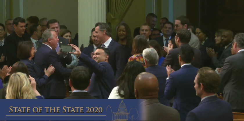 Gov. Gavin Newsom surrounded by lawmakers