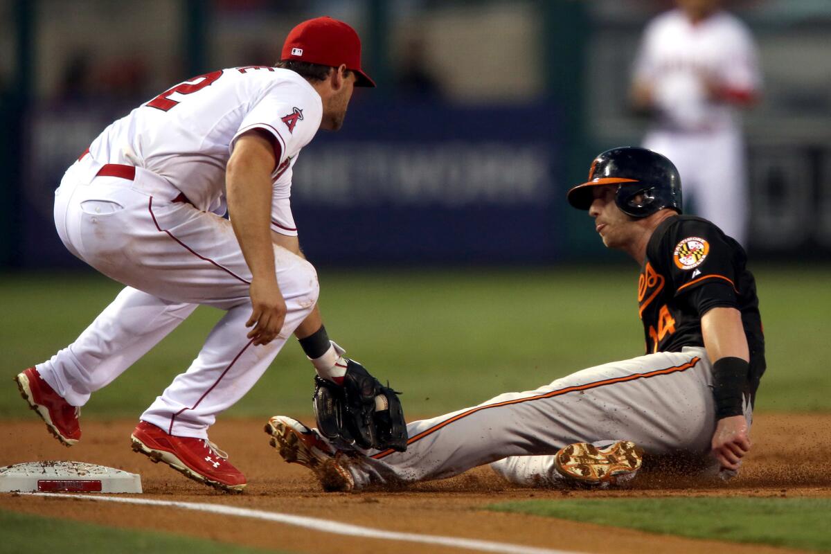 Angels third baseman Conor Gillaspie applies the tag to Orioles baserunner Nolan Reimold after Kole Calhoun threw a dart from right field.