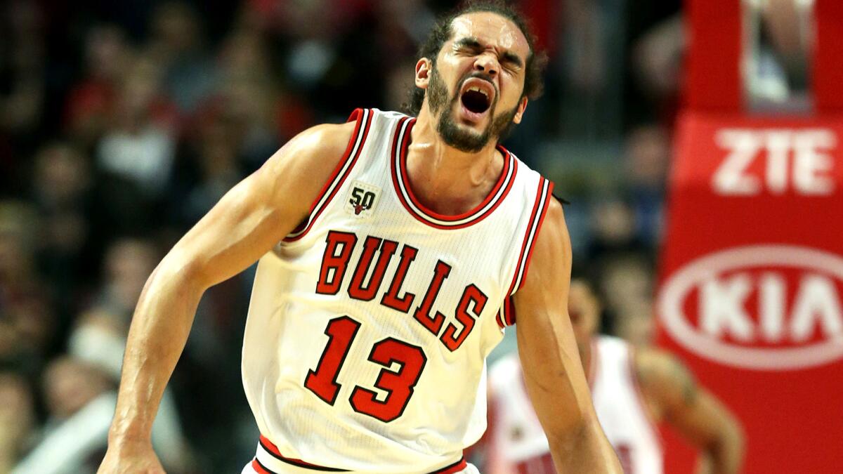 Bulls center Joakim Noah reacts after separating his left shoulder during the second quarter of a game against the Mavericks on Friday.