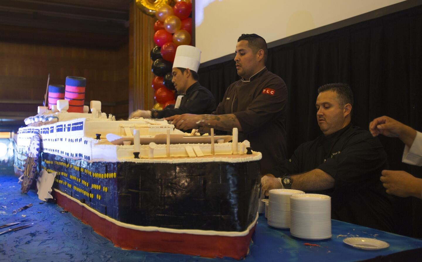 Chef Jose Barajas, center, gets help slicing his 600 pound, 20-foot long Queen Mary cake.
