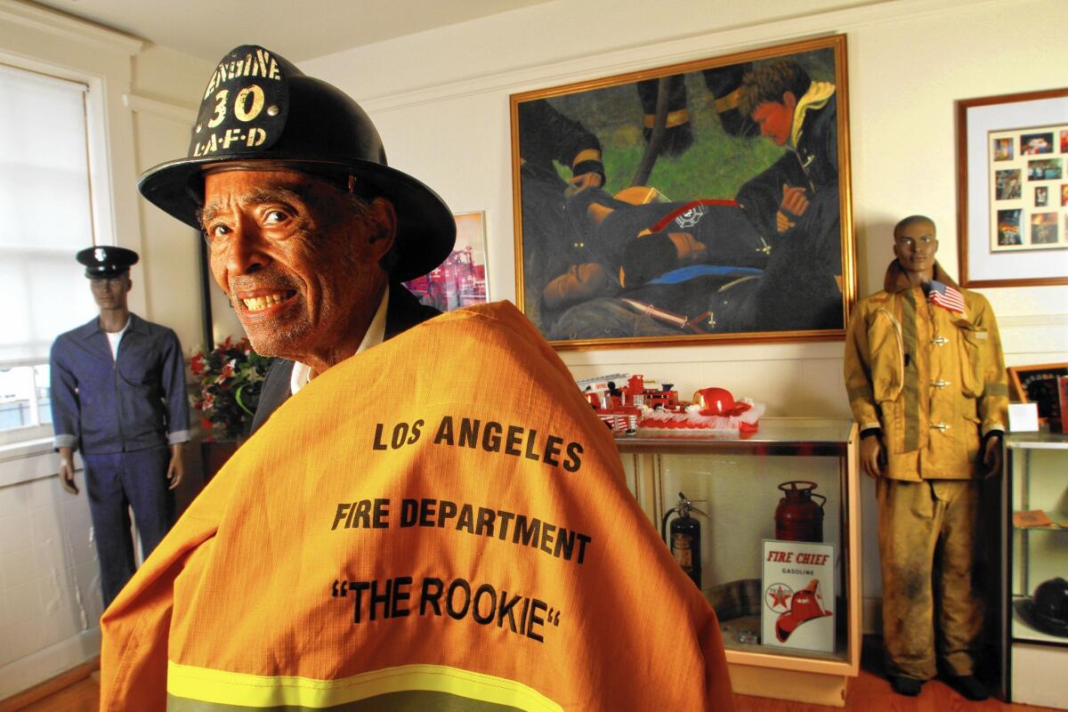 Retired Los Angeles city firefighter Arnett Hartsfield Jr. dons an original Bakelite helmet from Fire Station 30 on Central Avenue in downtown Los Angeles, where he began his LAFD career in 1940.