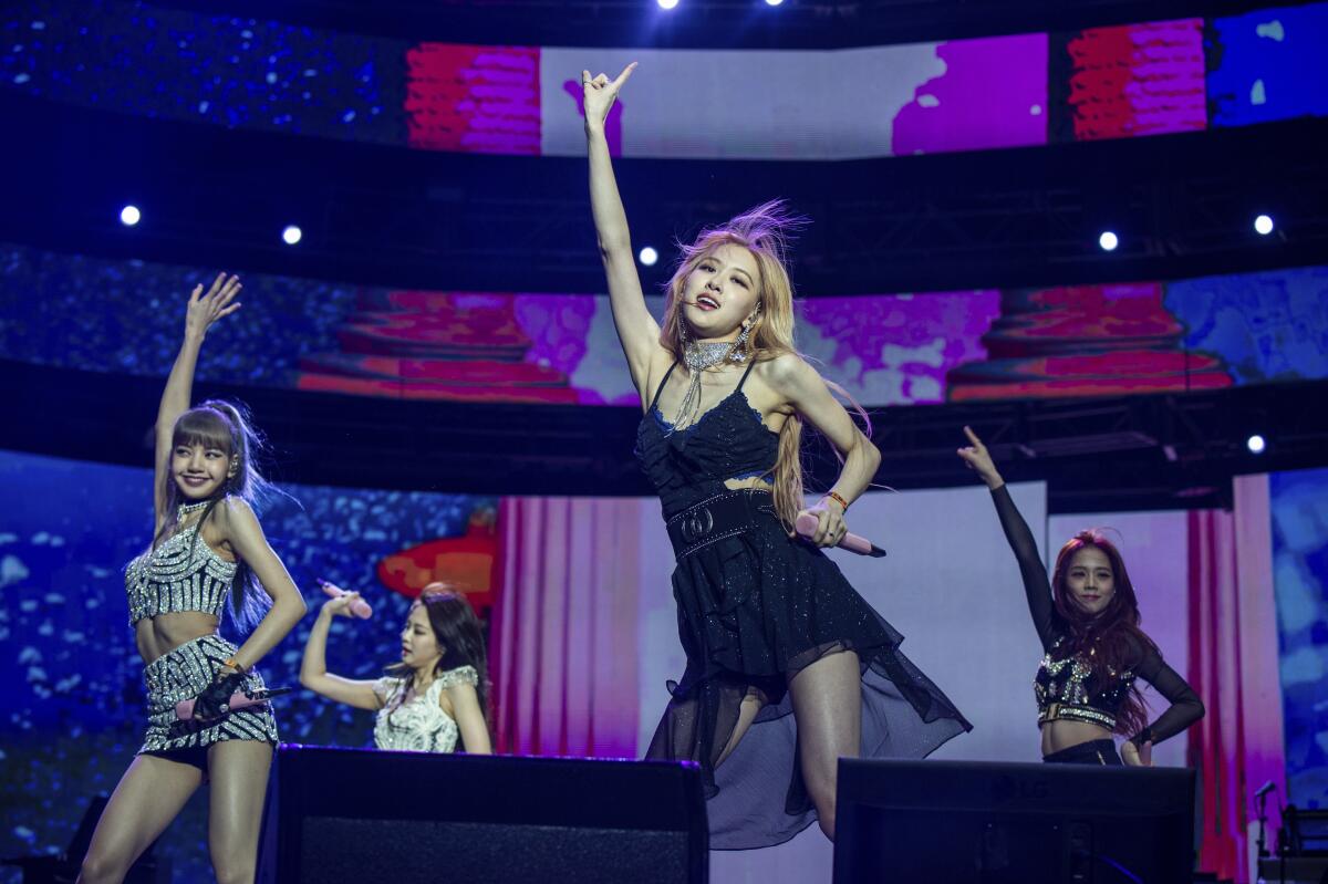 Four women dancing on a colorful stage