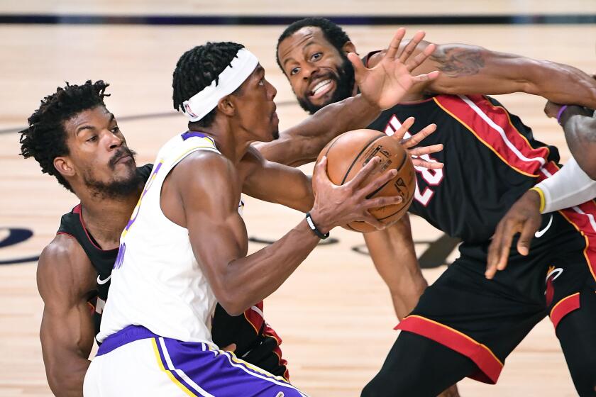 ORLANDO, FLORIDA OCTOBER 11, 2020-Lakers Rajon Rondo drives past Heat's Jimmy Butler.