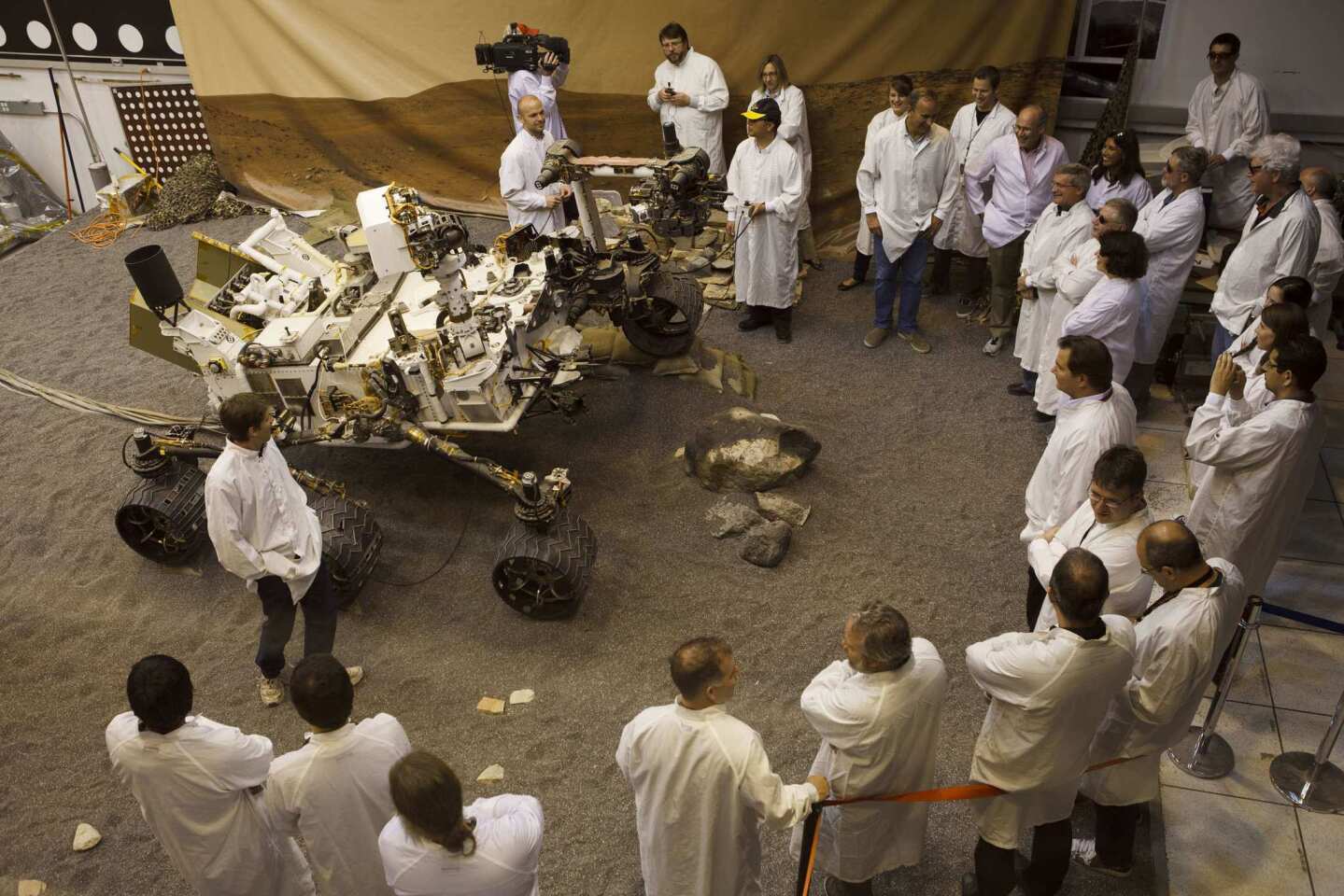 Scientists at the Jet Propulsion Laboratory in La Cañada Flintridge gather around a replica of the Mars rover Curiosity. After a journey of nearly nine months, the six-wheel laboratory is scheduled to touch down on the Red Planet at 10:31 p.m. PDT on Aug. 5.