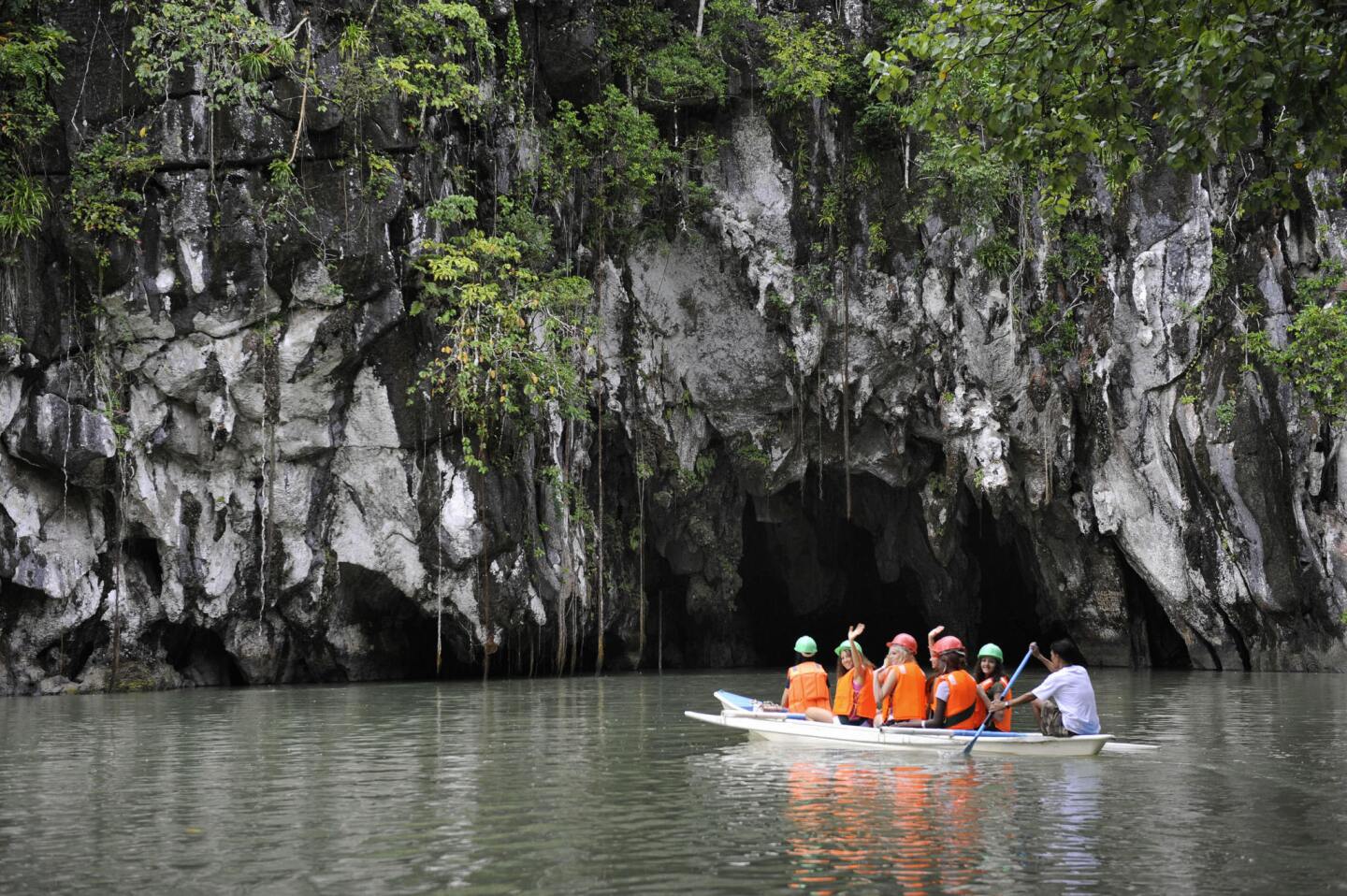 A tour boat approaches the entrance to the underground river in Palawan province, Philippines.