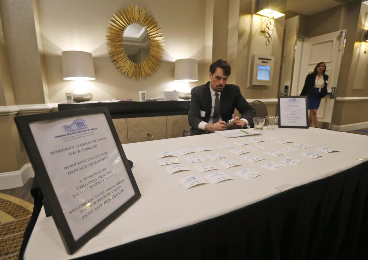 Senate Democratic aids staff a welcome table at the entrance to a closed fundraising breakfast.