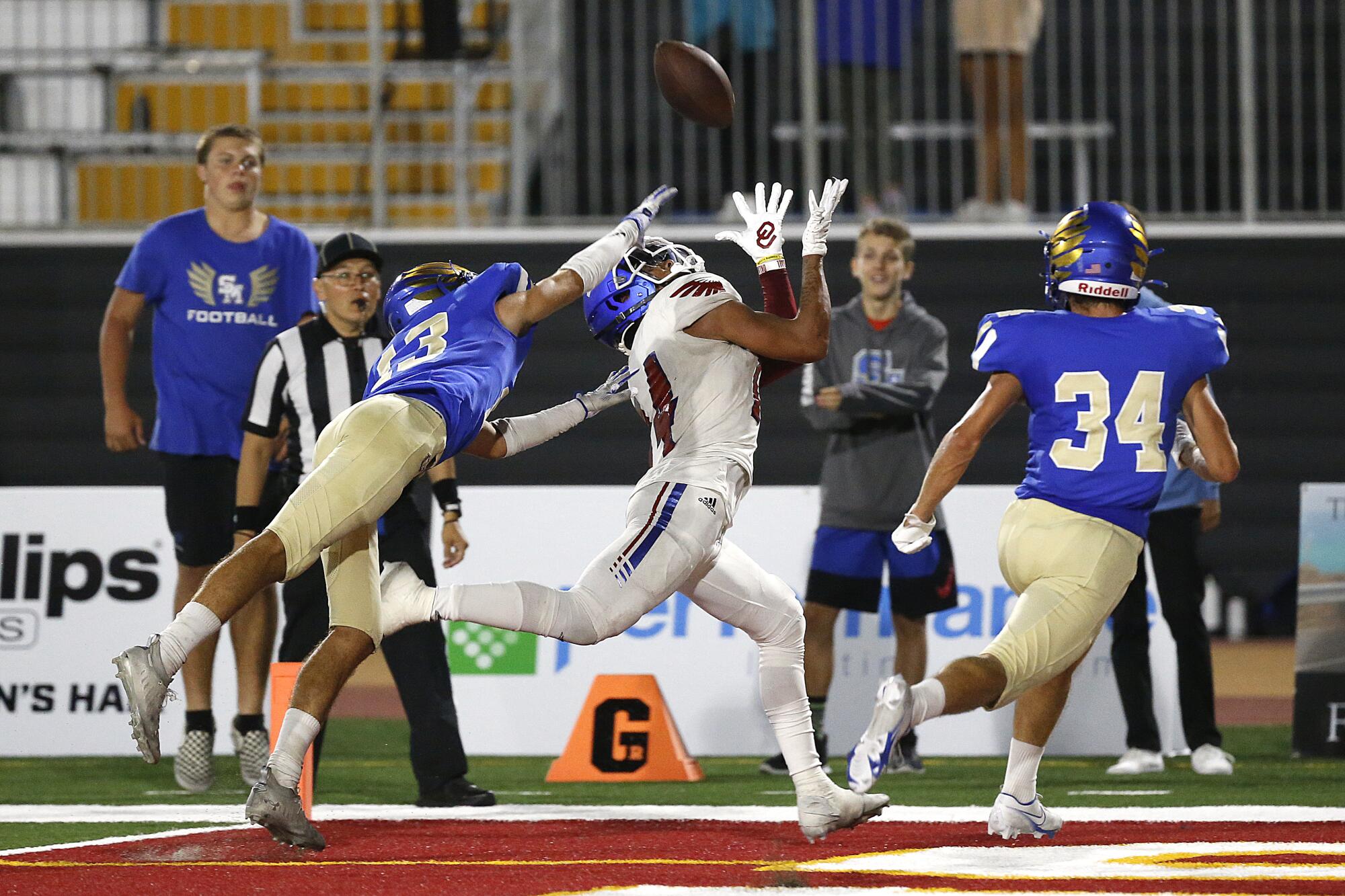 Los Alamitos's Makai Lemon attempts to haul in a pass while under pressure from Santa Margarita's Donovan Comestro.