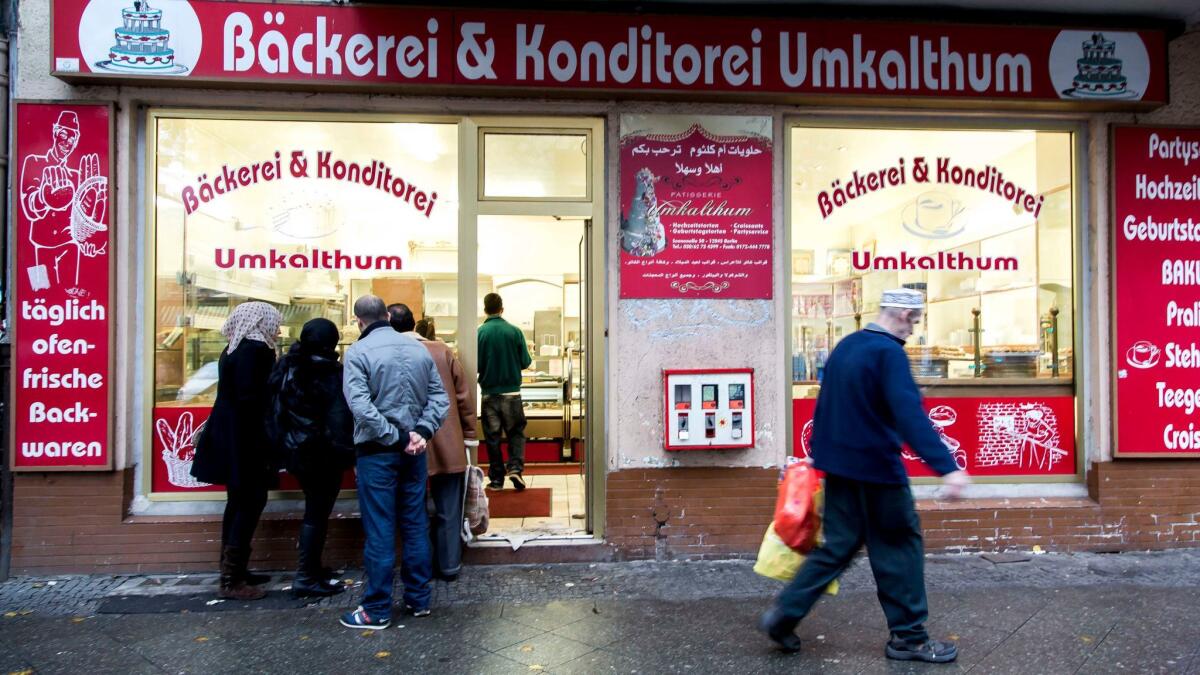 People look through the window of a Lebanese confectionery at Sonnenallee in the Neukoelln district of Berlin.