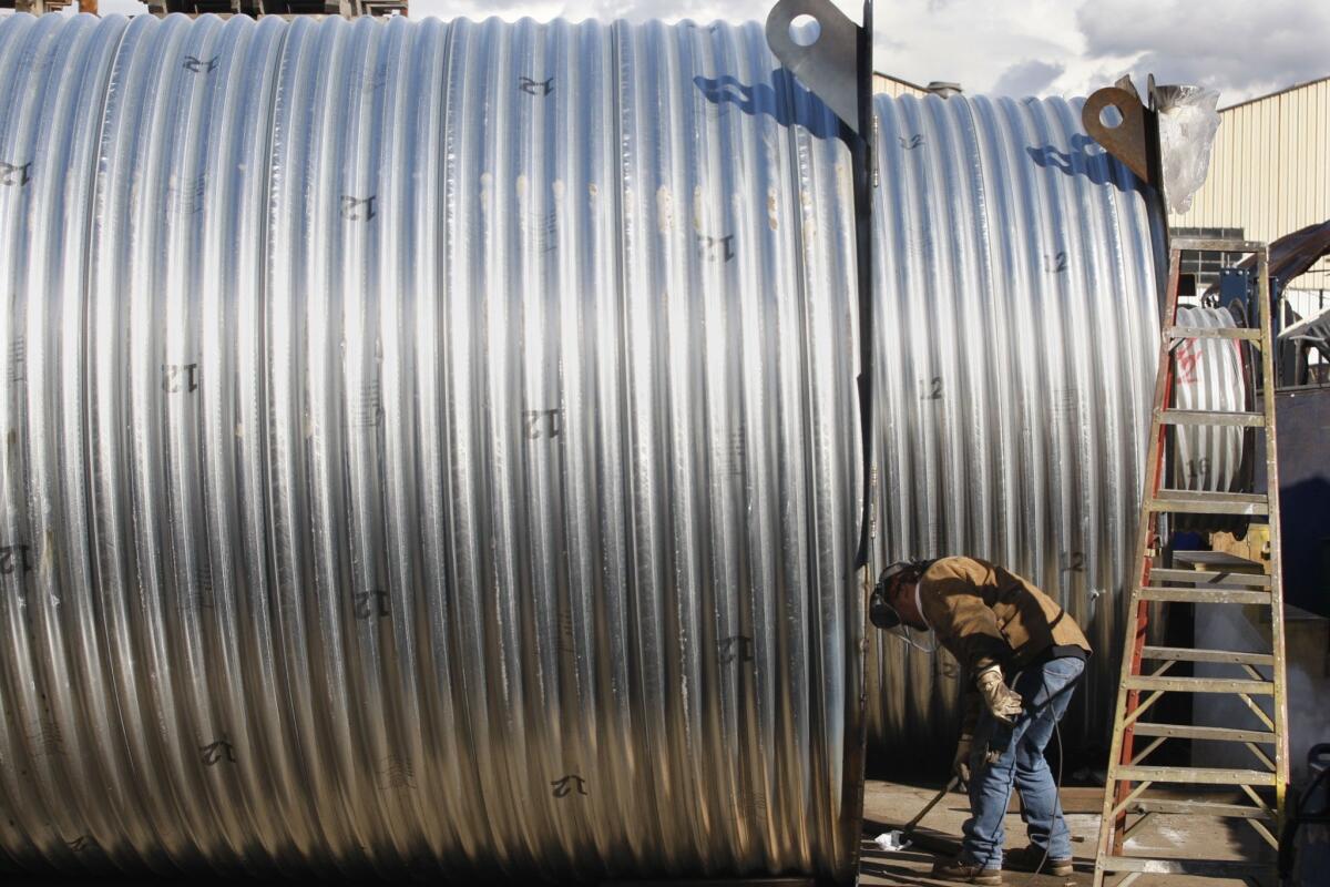 A worker welds the ends of a 40-foot shelter at Atlas Survival Shelters in Montebello in 2013.