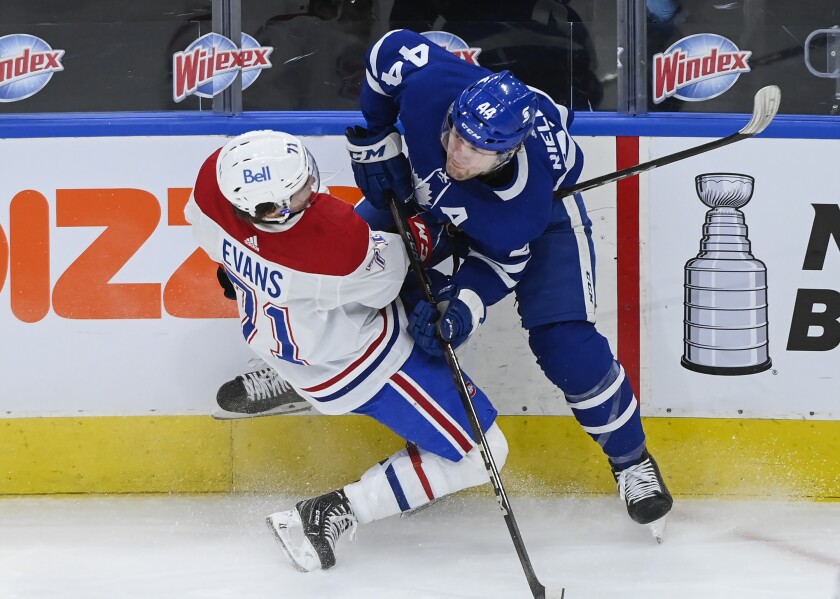 Toronto Maple Leafs defenseman Morgan Rielly (44) hits Montreal Canadiens forward Jake Evans (71) during the second period of an NHL hockey game Saturday, May 8, 2021, in Toronto. (Nathan Denette/The Canadian Press via AP)