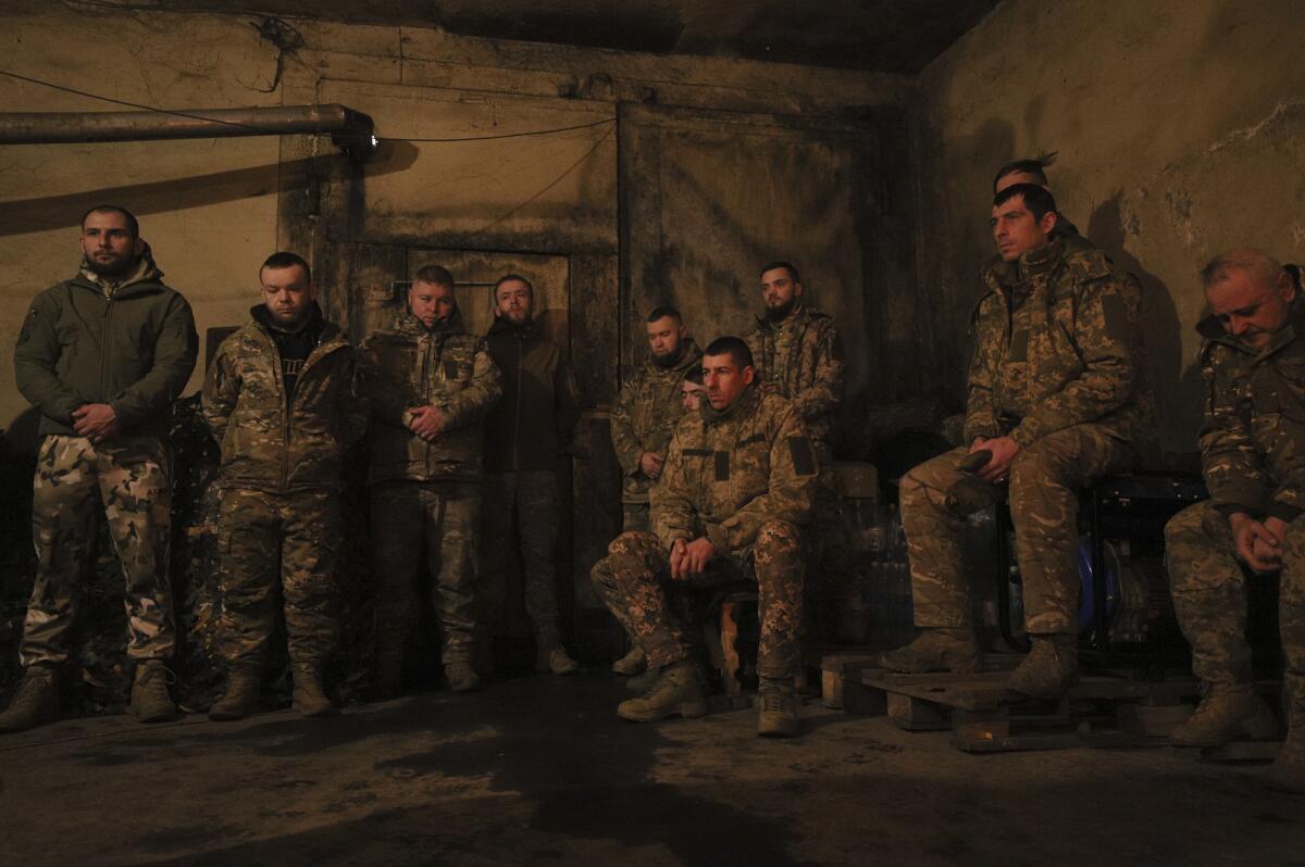 Ukrainian servicemen of the 72nd mechanized brigade sit or stand in uniform.