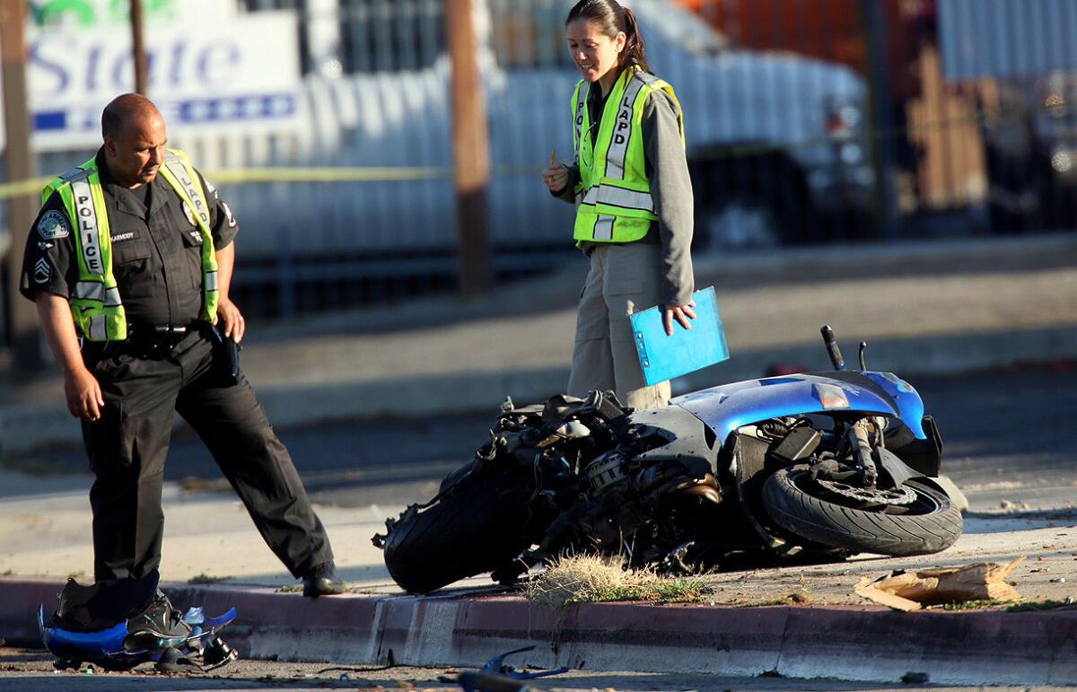 Los Angeles police officers look over the scene of a fatality crash that ended when a speeding and armed motorcyclist, who was being pursued by LAPD officers, was killed when his bike slammed into a fire hydrant in San Fernando.