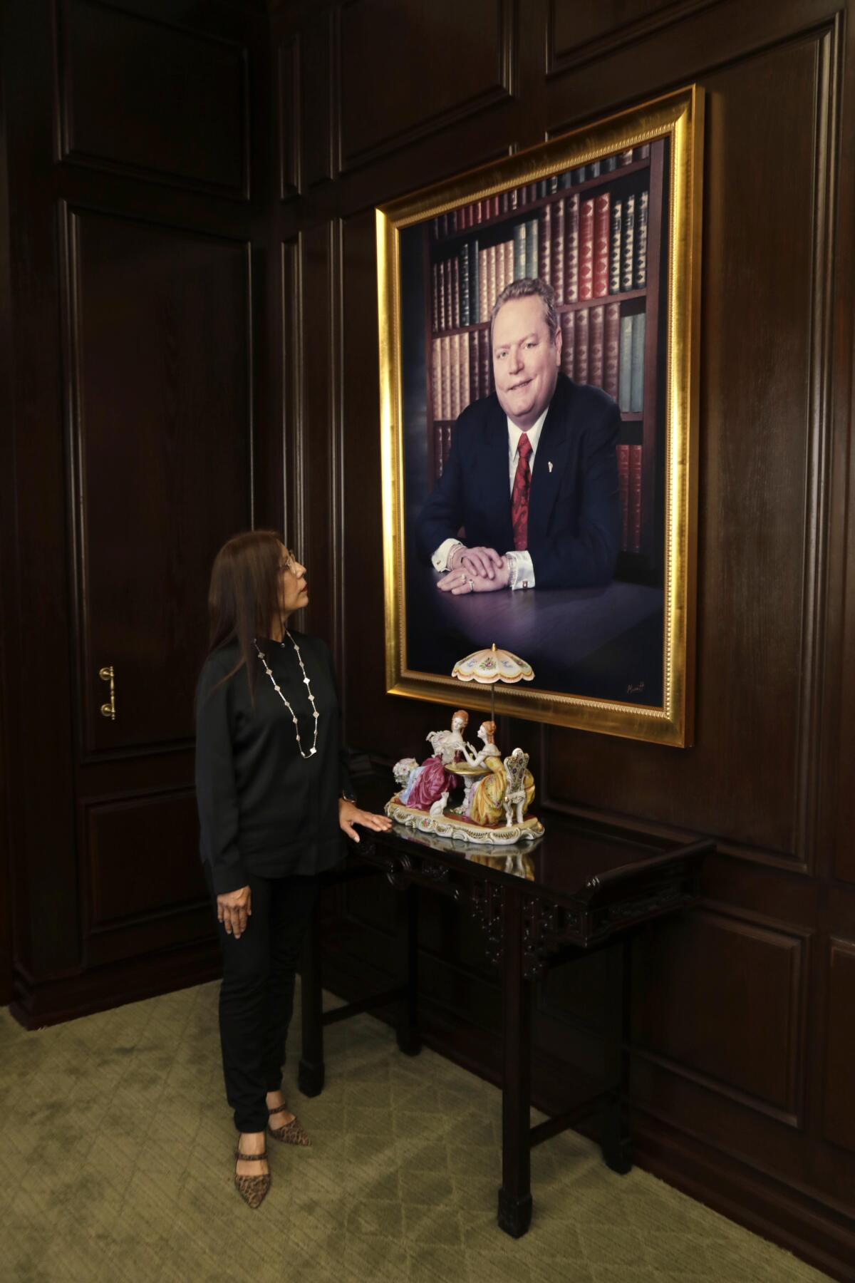 Liz Flynt looks up at a portrait of her late husband, Hustler publisher Larry Flynt, in her office in Beverly Hills.