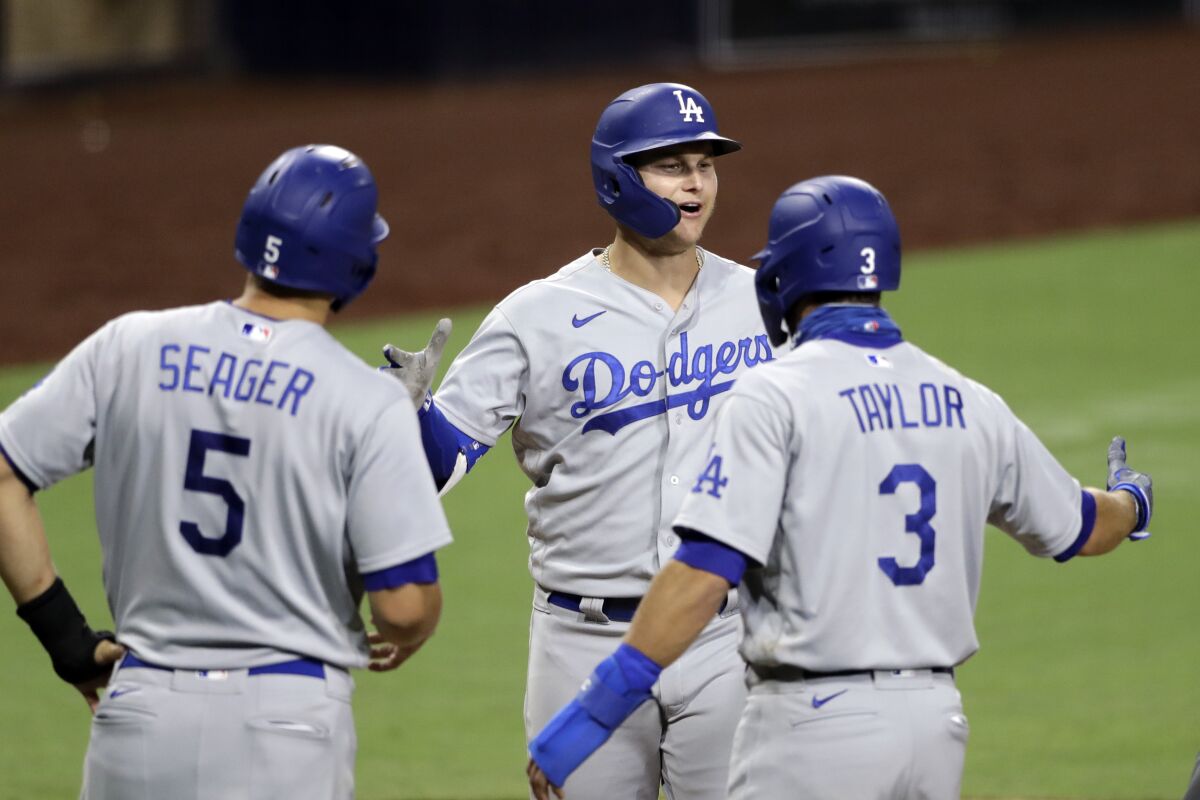 Dodgers' Joc Pederson is greeted by Chris Taylor and Corey Seager after hitting a three-run home run.
