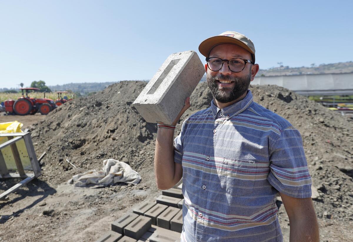 Jonathan Zaidman, director of engagement, stacks homemade bricks at the Ecology Center Farm.