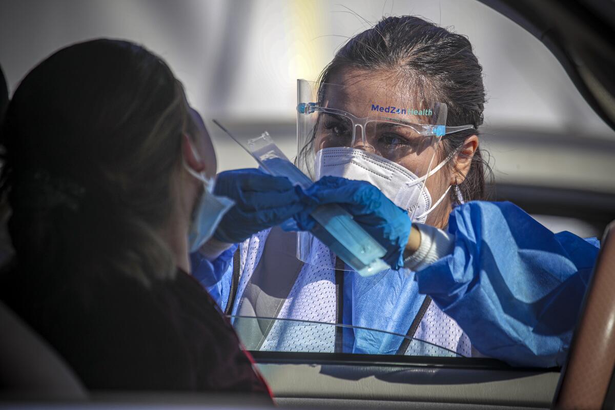 A healthcare worker administers a Covid test.