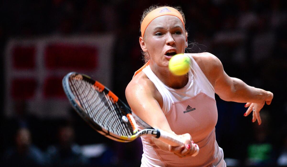 Caroline Wozniacki volleys a shot against Simona Halep during their semifinal match at the Porsche Grand Prix on Saturday.