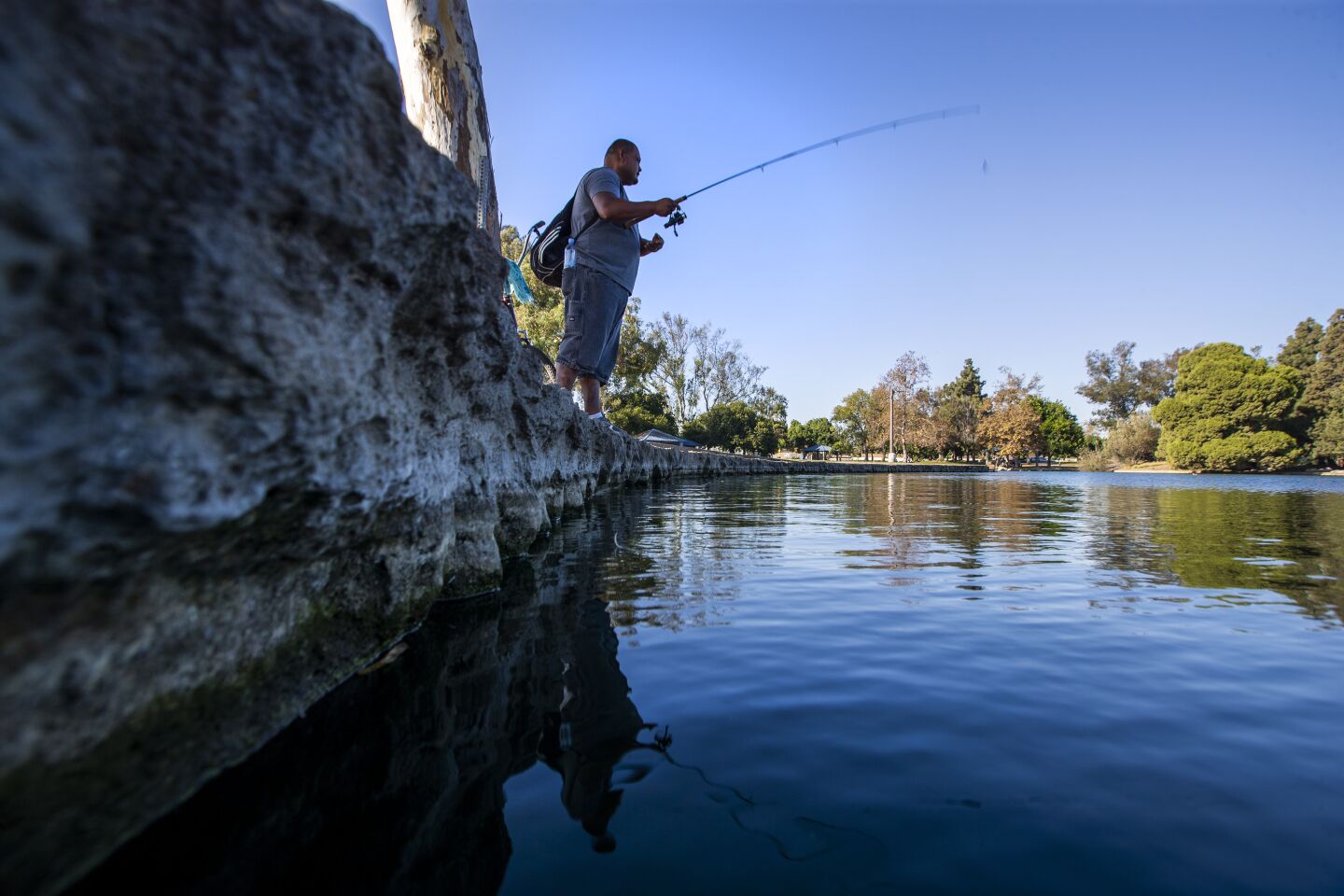 Jose Magana of Santa Ana fishes for large mouth bass Tuesday amid a heat wave at Centennial Regional Park in Santa Ana.