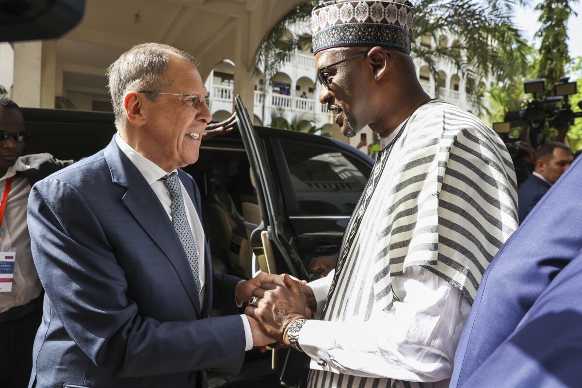 In this handout photo released by Russian Foreign Ministry Press Service, Mali's Foreign Minister Abdoulaye Diop, right, welcomes Russia's Foreign Minister Sergey Lavrov during their meeting in Bamako, Mali, Tuesday, Feb. 7, 2023. (Russian Foreign Ministry Press Service via AP)