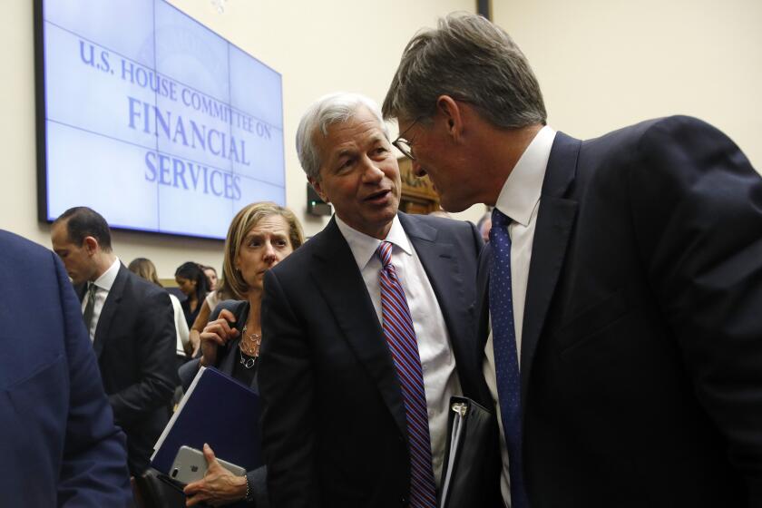 JPMorgan Chase chairman and CEO Jamie Dimon, center, speaks with Citigroup CEO Michael Corbat during a break in testimony before a House Financial Services Committee hearing, Wednesday, April 10, 2019, on Capitol Hill in Washington. (AP Photo/Patrick Semansky)