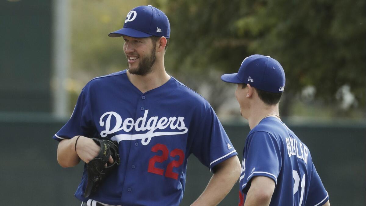 Dodgers pitchers Clayton Kershaw, left, and Walker Buehler chat during a spring training workout session on Feb. 13.