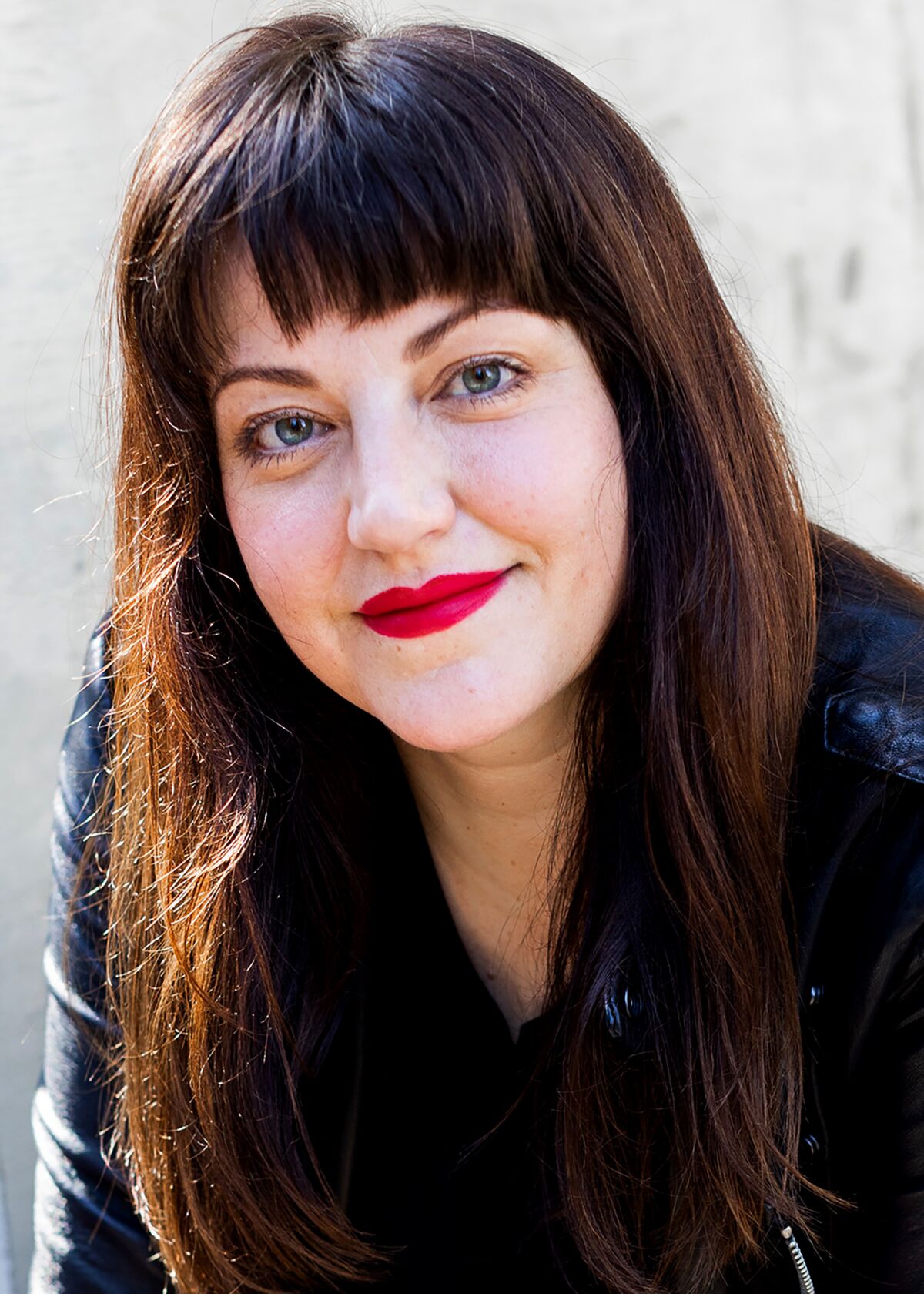 A smiling woman in black with long brown hair.
