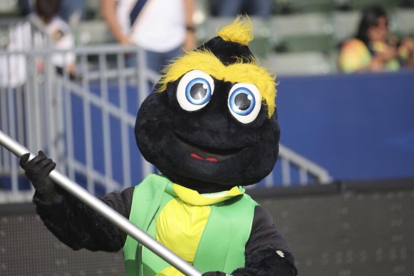 The Los Angeles Galaxy mascot Cozmo waves a victory flag after an MLS soccer game against the San Jose Earthquakes, Saturday, May 29, 2021, at Dignity Health Sports Center in Carson, Calif. (AP Photo/Peter Joneleit)