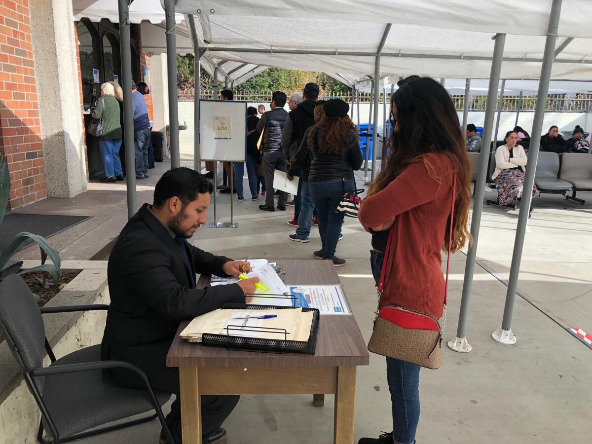 Un funcionario revisa los documentos de una usuaria en la entrada del Consulado General de Guatemala en Los Ángeles.