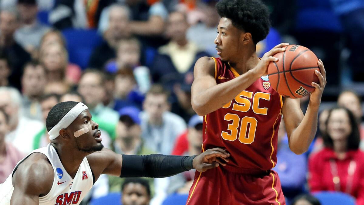 USC guard Elijah Stewart weighs his options as he's defended by SMU guard Ben Emelogu II March 17 in the NCAA tournament. Stewart scored 22 points, including the game winner, in the Trojans' 66-65 victory.